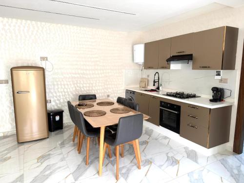 a kitchen with a table and chairs and a refrigerator at bel appartement à centre Mahdia plage 2 in Kenitra