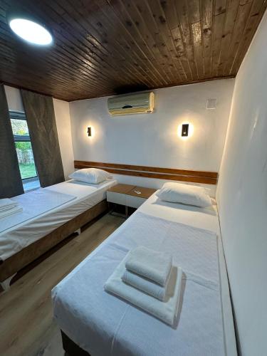 a small room with two beds and a window at La Dimora Villas in Kaş