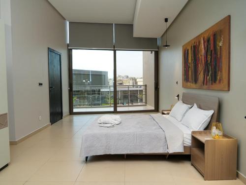 达喀尔Noom Hotel Dakar Sea Plaza, a member of Radisson Individuals的一间带床和大窗户的卧室