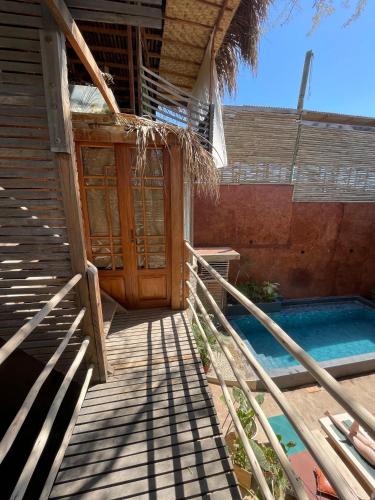 a porch of a house with a swimming pool at Eco Lodge Mancora in Máncora