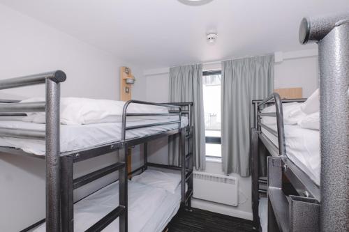 two bunk beds in a room with a window at Astor Oxford Street in London