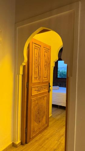 a wooden door in a room with an archway at Auberge Alwahabi in Chefchaouene