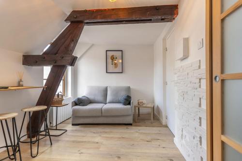 a living room with a couch and a brick wall at L'Appart des Platanes in Romorantin