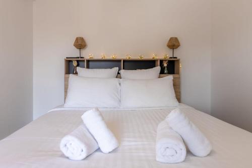 a white bed with two white towels on it at L'Appart des Platanes in Romorantin