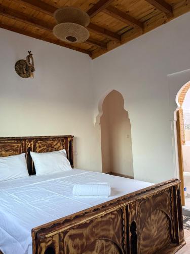 a bedroom with a large bed with a wooden frame at Auberge Alwahabi in Chefchaouene