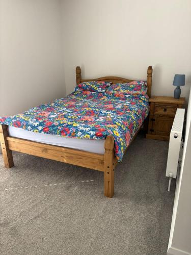 a bed with a floral comforter in a bedroom at The Nineteenth at Portstewart in Portstewart