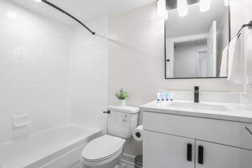 a white bathroom with a toilet and a sink at Pentagon City Escape - Contemporary & Comfy in Arlington