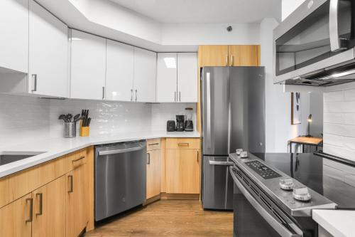a kitchen with wooden cabinets and stainless steel appliances at Pentagon City Escape - Contemporary & Comfy in Arlington