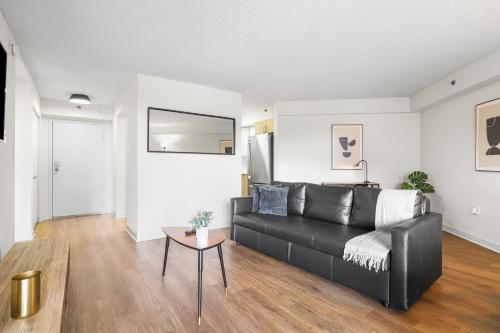 a living room with a black couch and a table at Pentagon City Escape - Contemporary & Comfy in Arlington