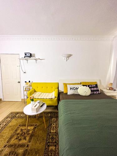a bedroom with a bed and a yellow couch at Horizon Home - Netflix n Chill in Ho Chi Minh City