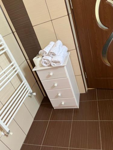 a bathroom with a white dresser with towels at Helen Rooms Vama Veche in Vama Veche