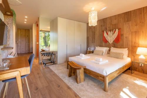 a bedroom with a bed and a table and a desk at Nature Escape with Pool & BBQ in Viana do Castelo