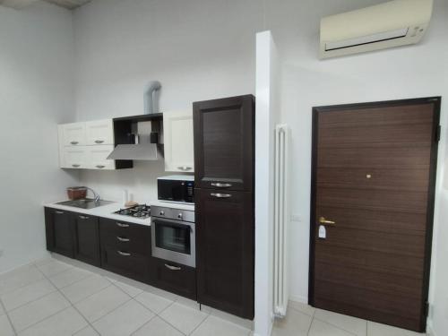 a kitchen with black cabinets and a stove at Le Torri Loft, exclusive comfort in the city center in Forlì