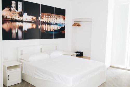 una camera bianca con un letto e un dipinto sul muro di Casa Del Capitano - Appartamento Accogliente - Molfetta a Molfetta