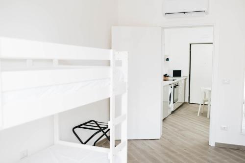 una camera da letto con pareti bianche e un letto a castello di Casa Del Capitano - Appartamento Accogliente - Molfetta a Molfetta