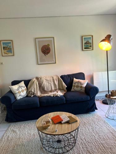 un salon avec un canapé bleu et une table dans l'établissement Le 33 Deauville, à Deauville
