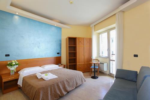 a bedroom with a bed and a couch at Hotel President in Alba Adriatica
