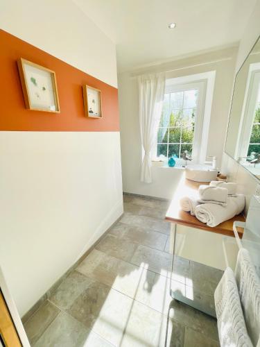 a bathroom with a sink and a window at Ferme les Chapelles Utah Beach in Angoville-au-Plain