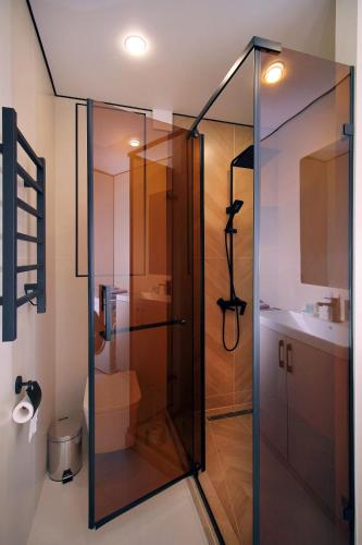 a glass shower in a bathroom with a sink at Center Almaty in Almaty