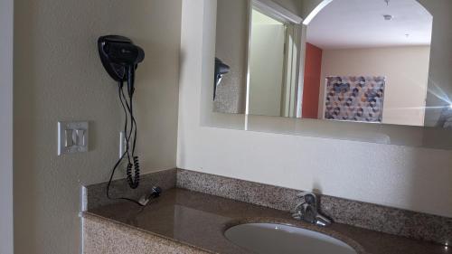 a bathroom with a sink and a mirror at Rodeway Inn & Suites in Humble