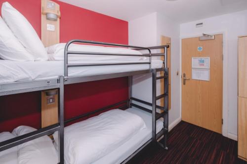 a room with two bunk beds and a red wall at Astor Oxford Street in London