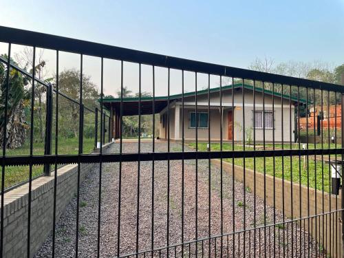 una valla con una casa en el fondo en Casa Atardecer, en Eldorado