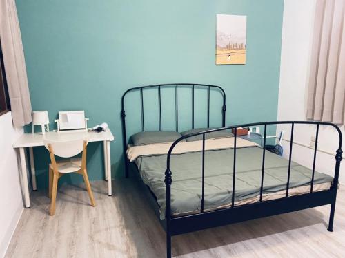 a bedroom with a bed and a desk and a table at 綠色的日子 in Nantou City