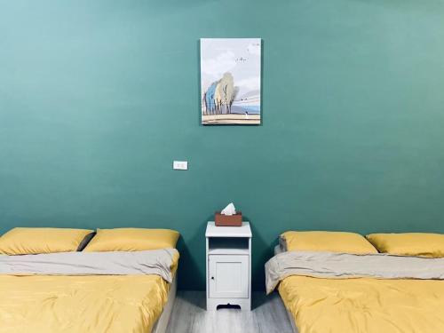 two beds sitting next to each other in a room at 綠色的日子 in Nantou City