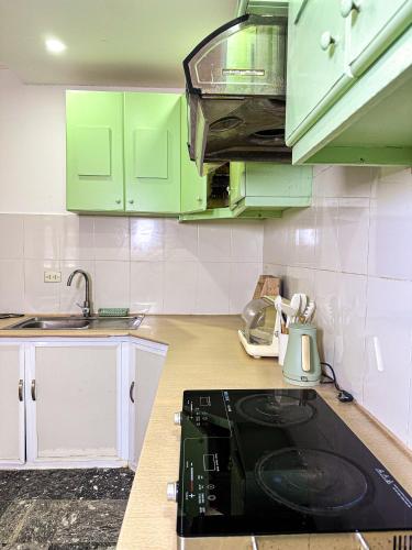 a kitchen with green cabinets and a black stove at Horizon Home - Netflix n Chill in Ho Chi Minh City