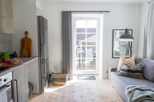 a living room with a couch and a door to a patio at Fully Equipped Cosy Flat Close to Malmö&Copenhagen in Vellinge