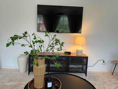 a living room with a table with a lamp and a plant at Fully Equipped Cosy Flat Close to Malmö&Copenhagen in Vellinge