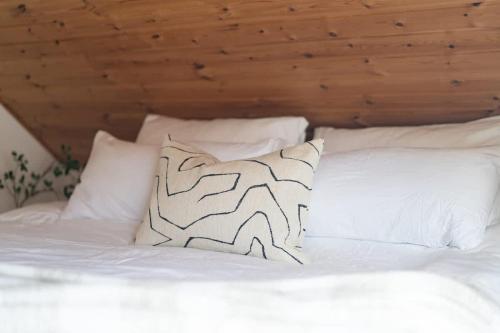 a white bed with white pillows and a wooden ceiling at Fully Equipped Apartment Close to Malmö & Copenhagen in Vellinge