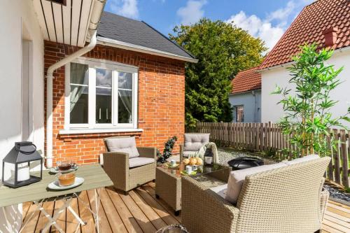a patio with chairs and a table on a wooden deck at Fully Equipped Apartment Close to Malmö & Copenhagen in Vellinge