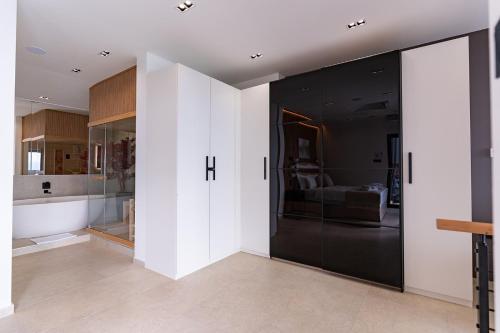 a pivot door in a room with a kitchen at Dream 1-Bedroom Villa with Heated Indoor Pool, Jacuzzi & Sauna and BBQ in Medveja
