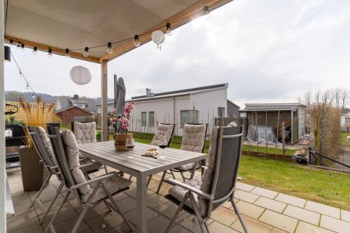 a wooden table and chairs on a patio at Fully Equipped Home in Båstad with Cozy Patio in Båstad