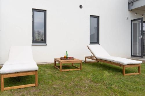 two chairs and a coffee table in a yard at Fully Equipped Home in Båstad with Cozy Patio in Båstad