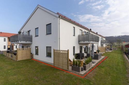 a large white building with a yard at Earthy Ground Floor Home with Patio Sunbeds Greenery in Båstad