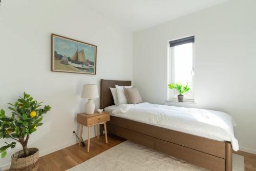 a white bedroom with a bed and a window at Earthy Ground Floor Home with Patio Sunbeds Greenery in Båstad