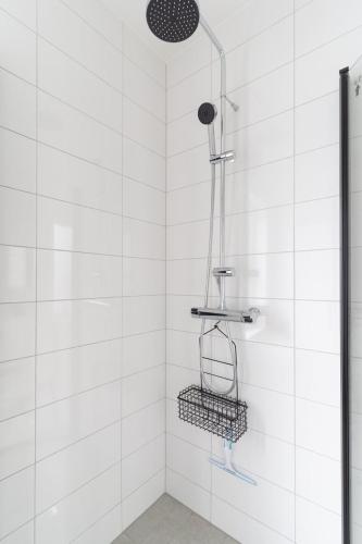 a bathroom with a shower with white tiles at Earthy Ground Floor Home with Patio Sunbeds Greenery in Båstad