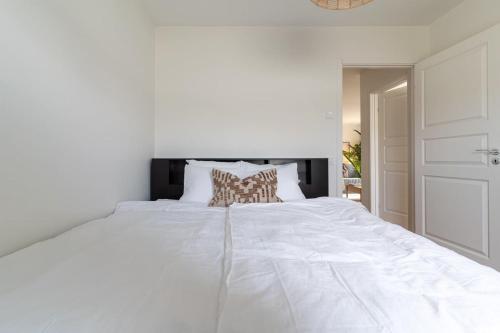 a white bedroom with a large white bed at Earthy Ground Floor Home with Patio Sunbeds Greenery in Båstad