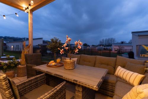 a patio with a couch and a table at Earthy Ground Floor Home with Patio Sunbeds Greenery in Båstad