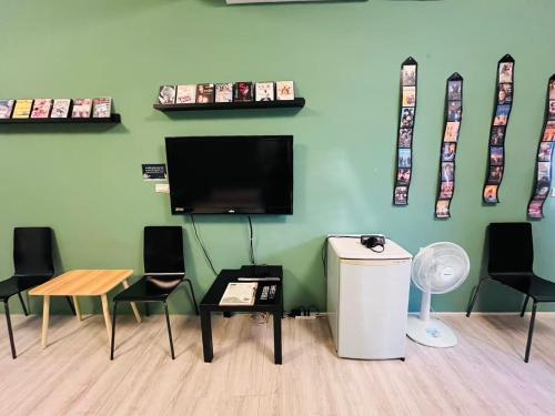 a room with chairs and a flat screen tv on a wall at 綠色的日子 in Nantou City