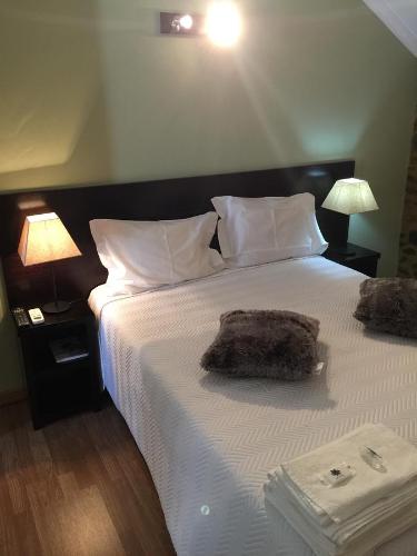 a bedroom with a large white bed with two lamps at Casas do Terreiro in Seia