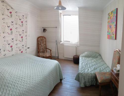 une chambre avec un lit, une chaise et une fenêtre dans l'établissement SOL'ANGE Maison d'Hotes, à Clamart