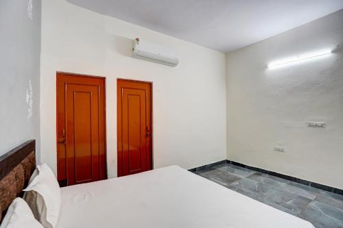 two doors in a room with two beds at Hotel O Conifer INN in Meerut