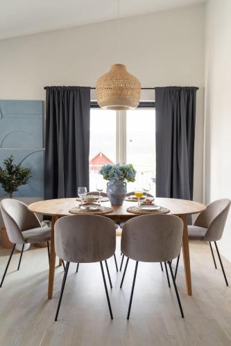 ein Esszimmer mit einem Holztisch und Stühlen in der Unterkunft Modern Beachy Home with Terrace Charm First Floor in Båstad