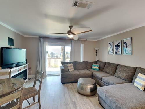 a living room with a couch and a flat screen tv at Coconuts Beach House in Pensacola Beach