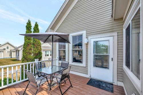 a table and chairs on a balcony with an umbrella at The King Eider - 24 Meadow View in Cherry Valley