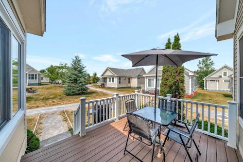 a table and chairs on a deck with an umbrella at The King Eider - 24 Meadow View in Cherry Valley