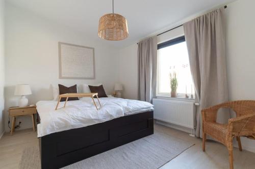 a bedroom with a bed and a desk and a window at Chocolaty Warmth Home 3BR Flat with Cozy Balcony in Båstad